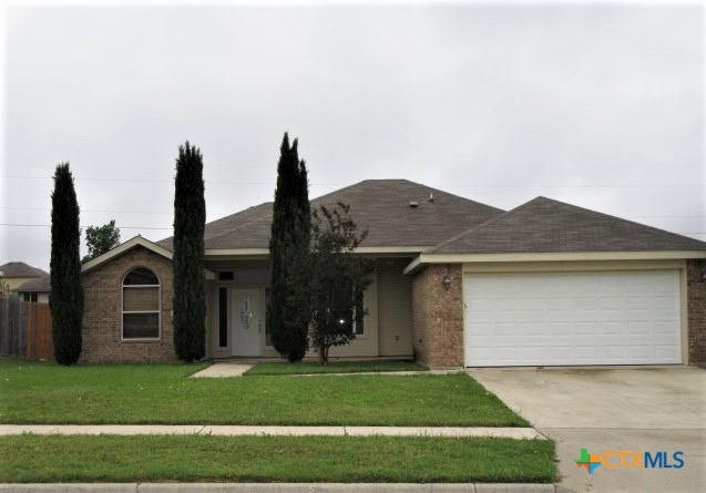 a front view of a house with a garden and yard