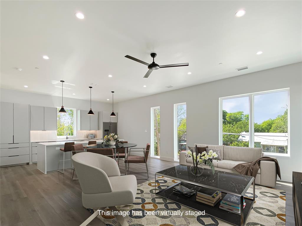 a living room with furniture ceiling fan and a large window