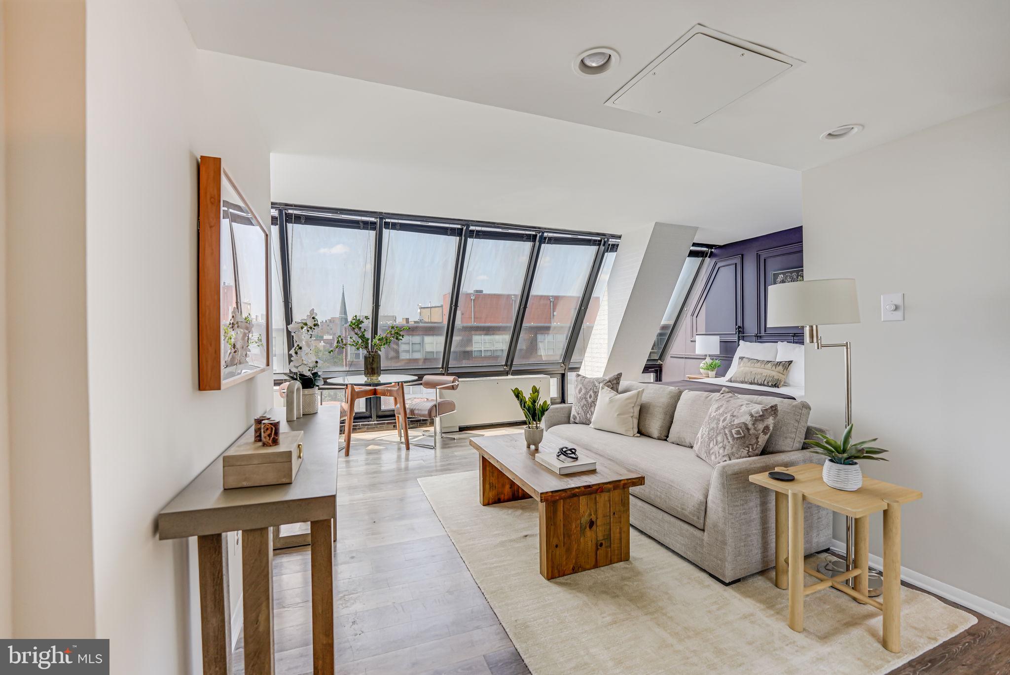 a living room with furniture and large windows