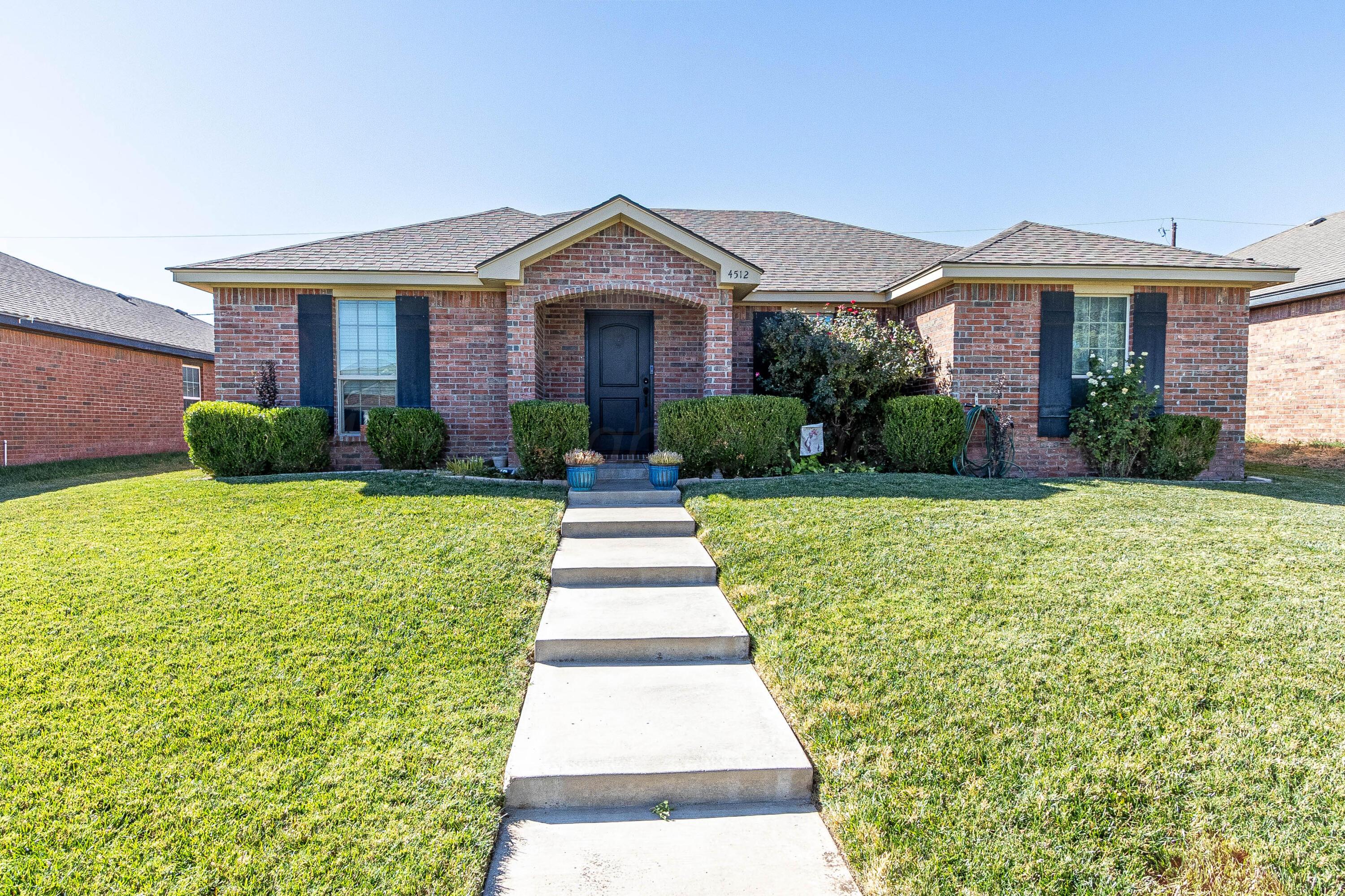 a front view of a house with yard and green space