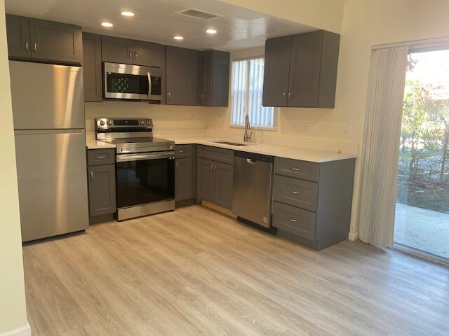 a kitchen with stainless steel appliances granite countertop a refrigerator and a stove top oven