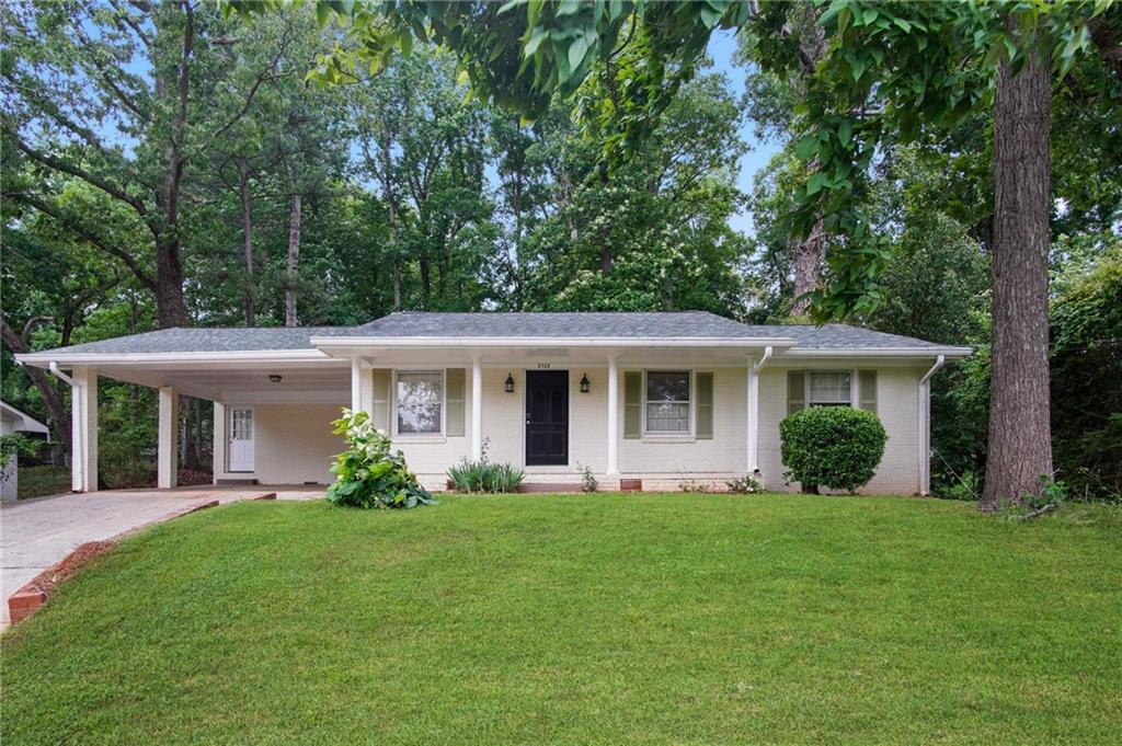 a front view of a house with a yard and potted plants