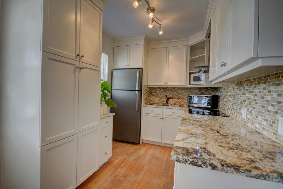 a kitchen with a refrigerator and a stove top oven