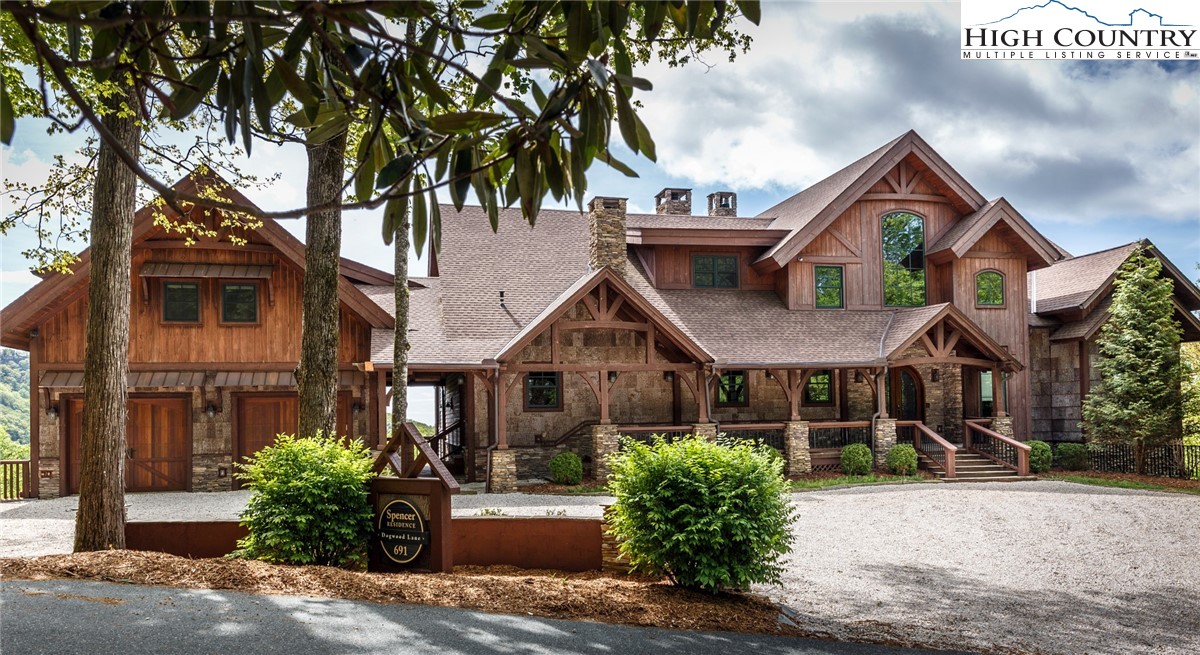 a front view of a house with a yard and potted plants