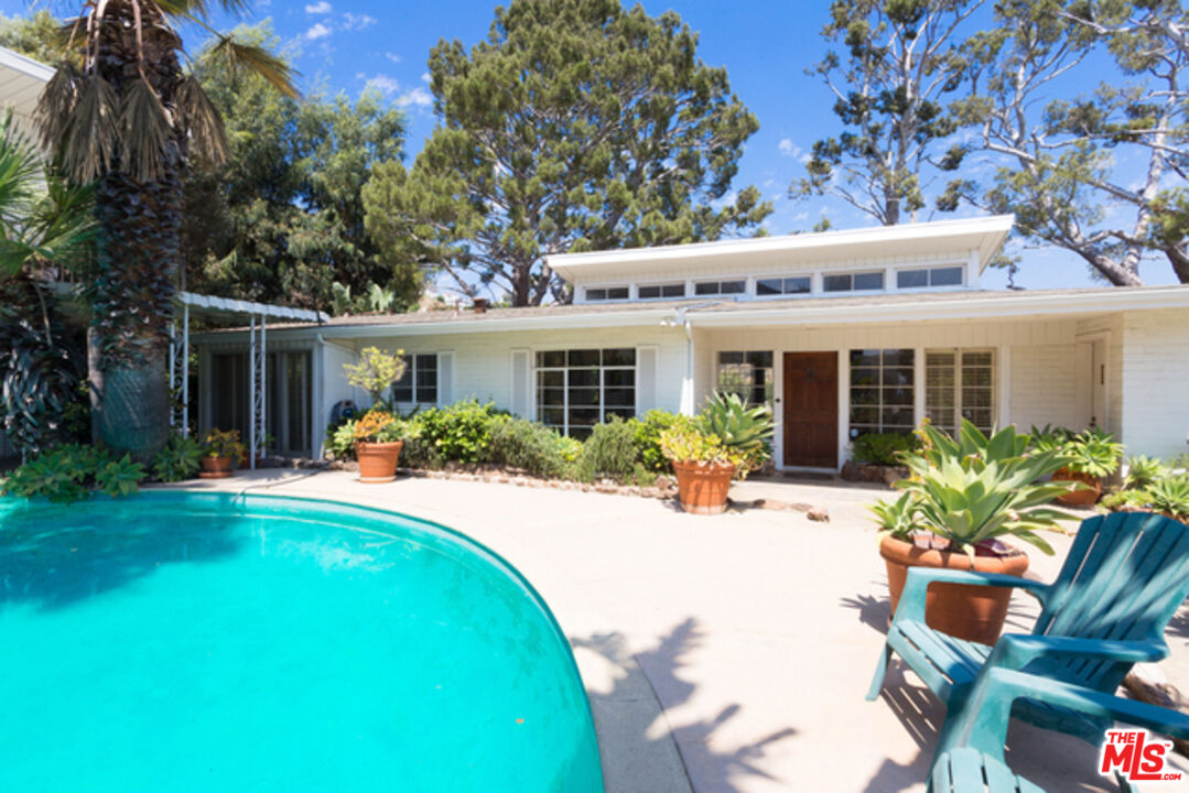 a view of a house with backyard sitting area and porch