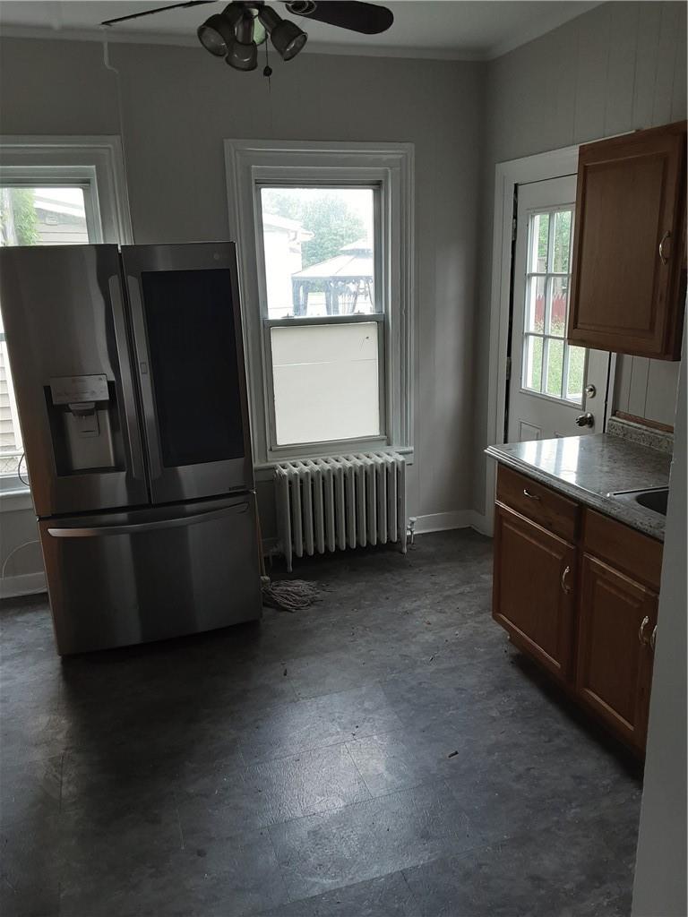 Kitchen featuring ceiling fan, fridge, and radiator heating unit