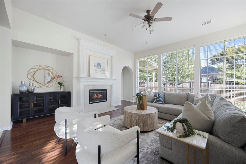 a living room with furniture a fireplace and a large window