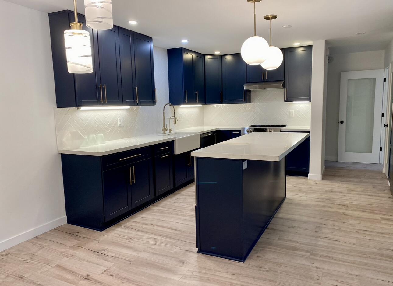 a kitchen with kitchen island granite countertop a sink dishwasher and wooden cabinets