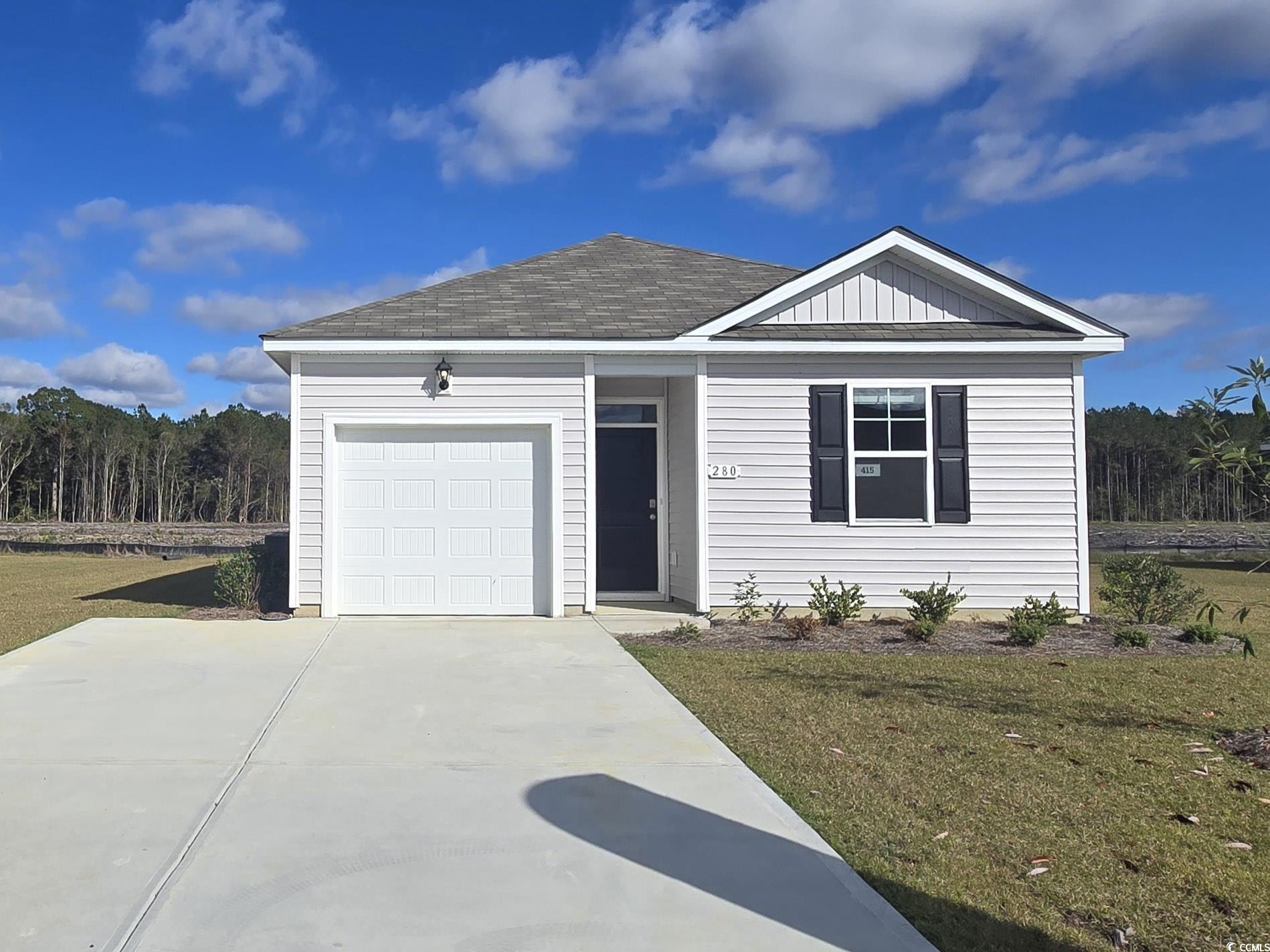 View of front of home with a front lawn and a gara