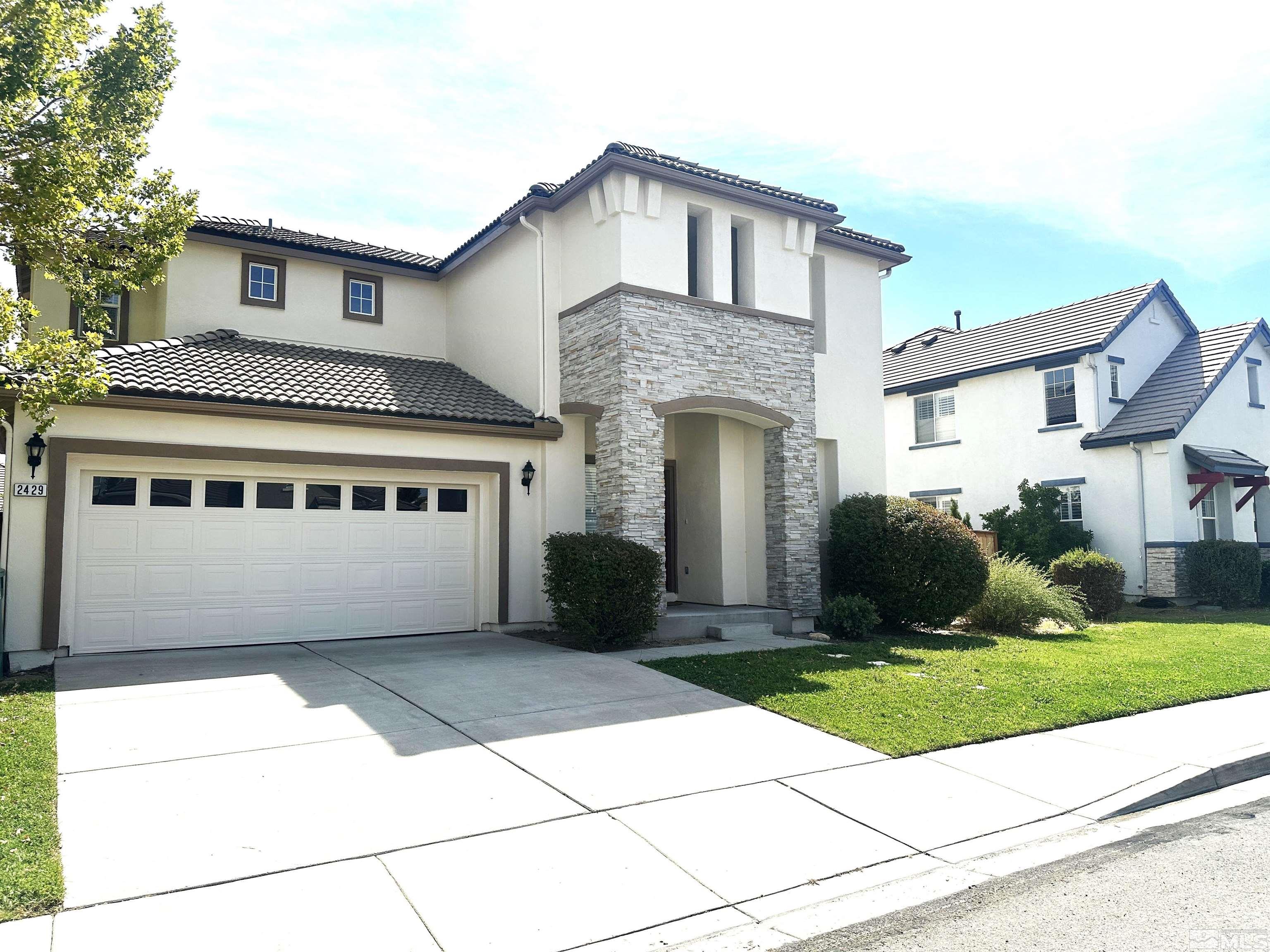 a front view of a house with a yard and garage