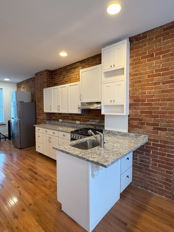 a kitchen with stainless steel appliances granite countertop a sink stove and cabinets