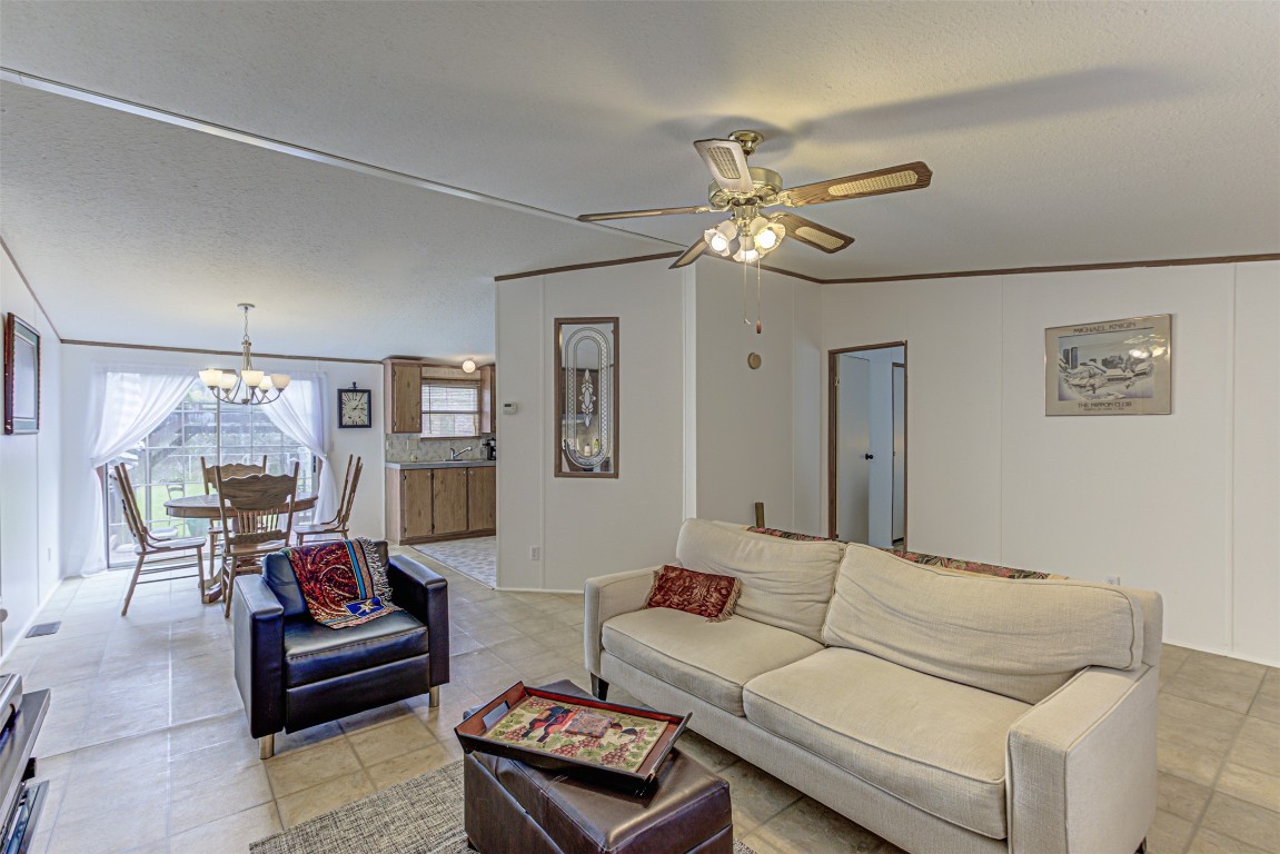 a living room with furniture a chandelier and a ceiling fan