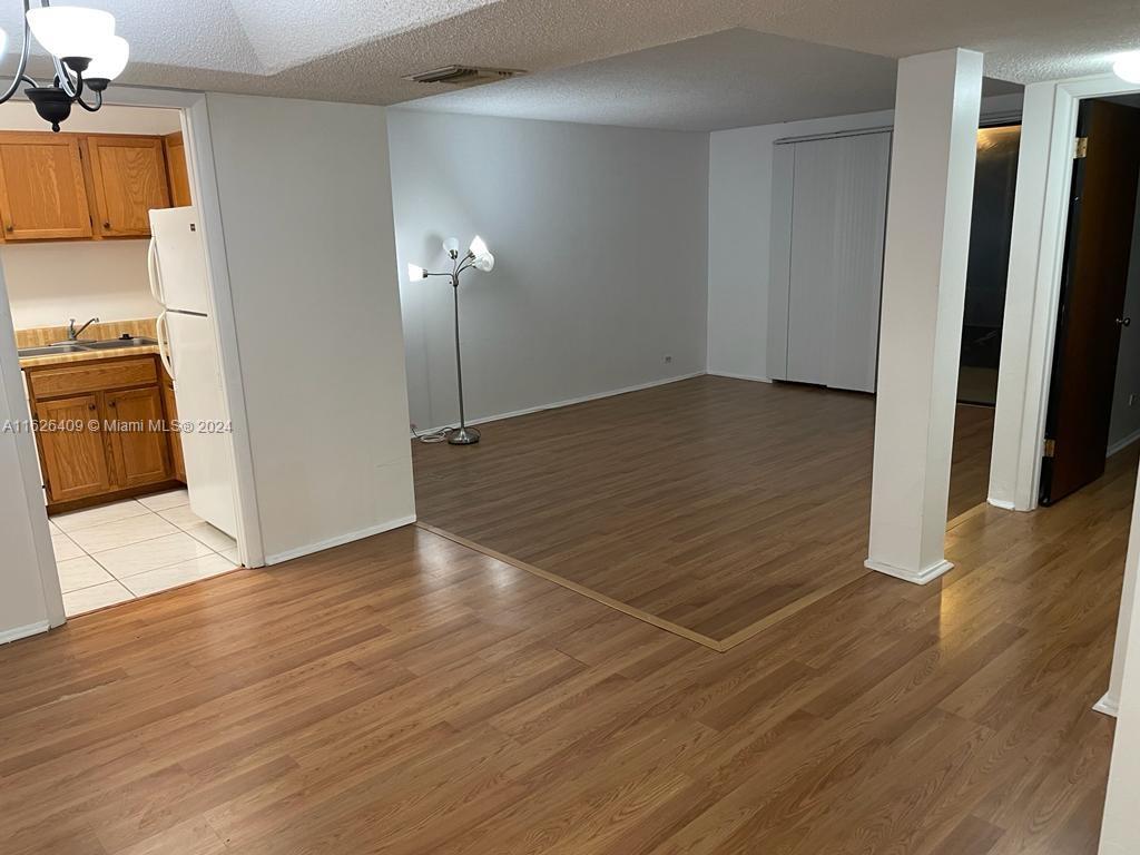 a view of a room with wooden floor and a sink