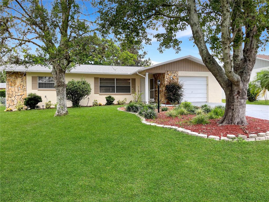 a front view of house with a garden and trees