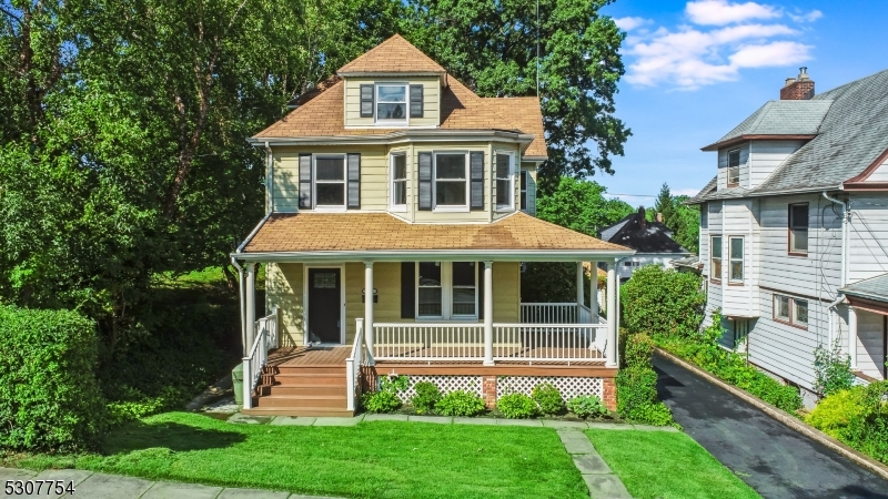 a front view of a house with a yard and potted plants