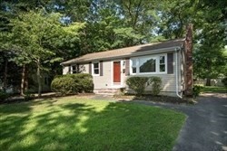 a view of a house with a yard and potted plants