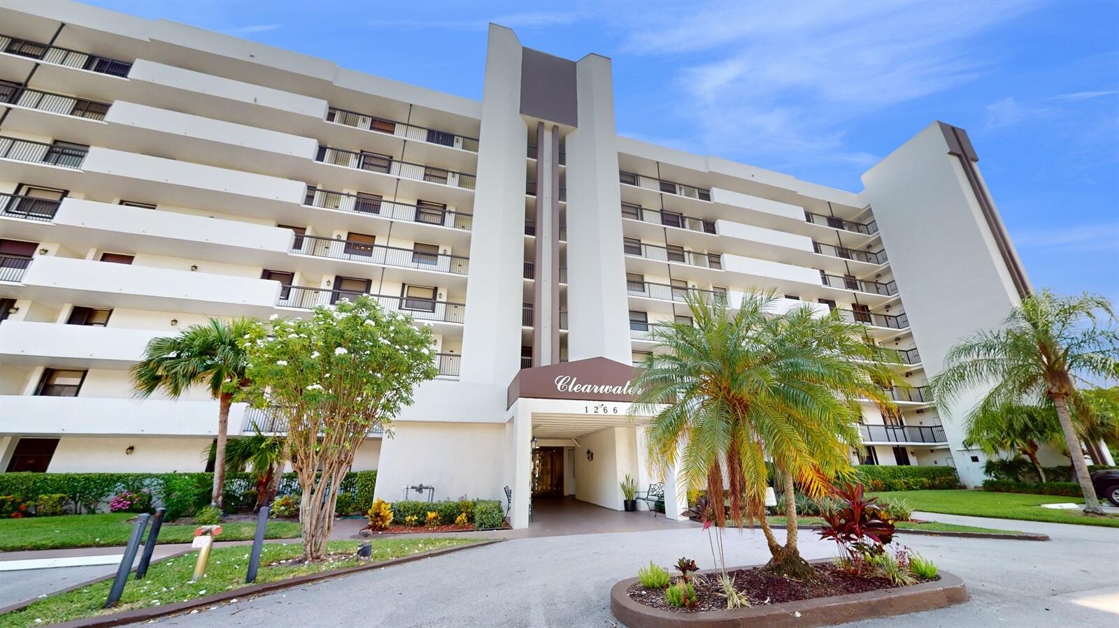 a front view of a building with palm trees