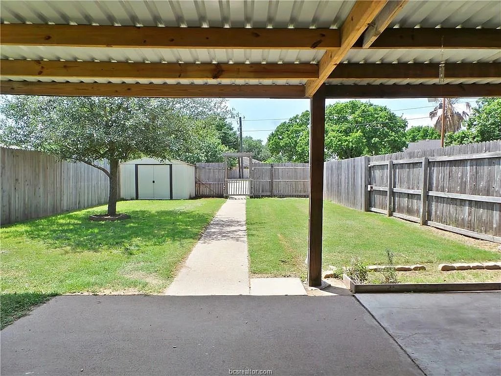 View of yard with a patio and a storage unit