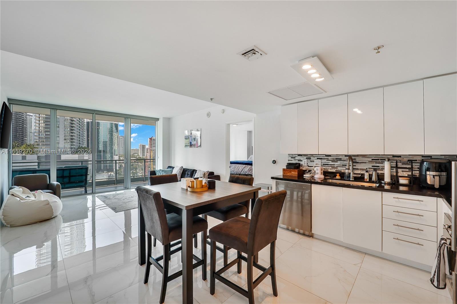 a kitchen with stainless steel appliances a table and chairs in it