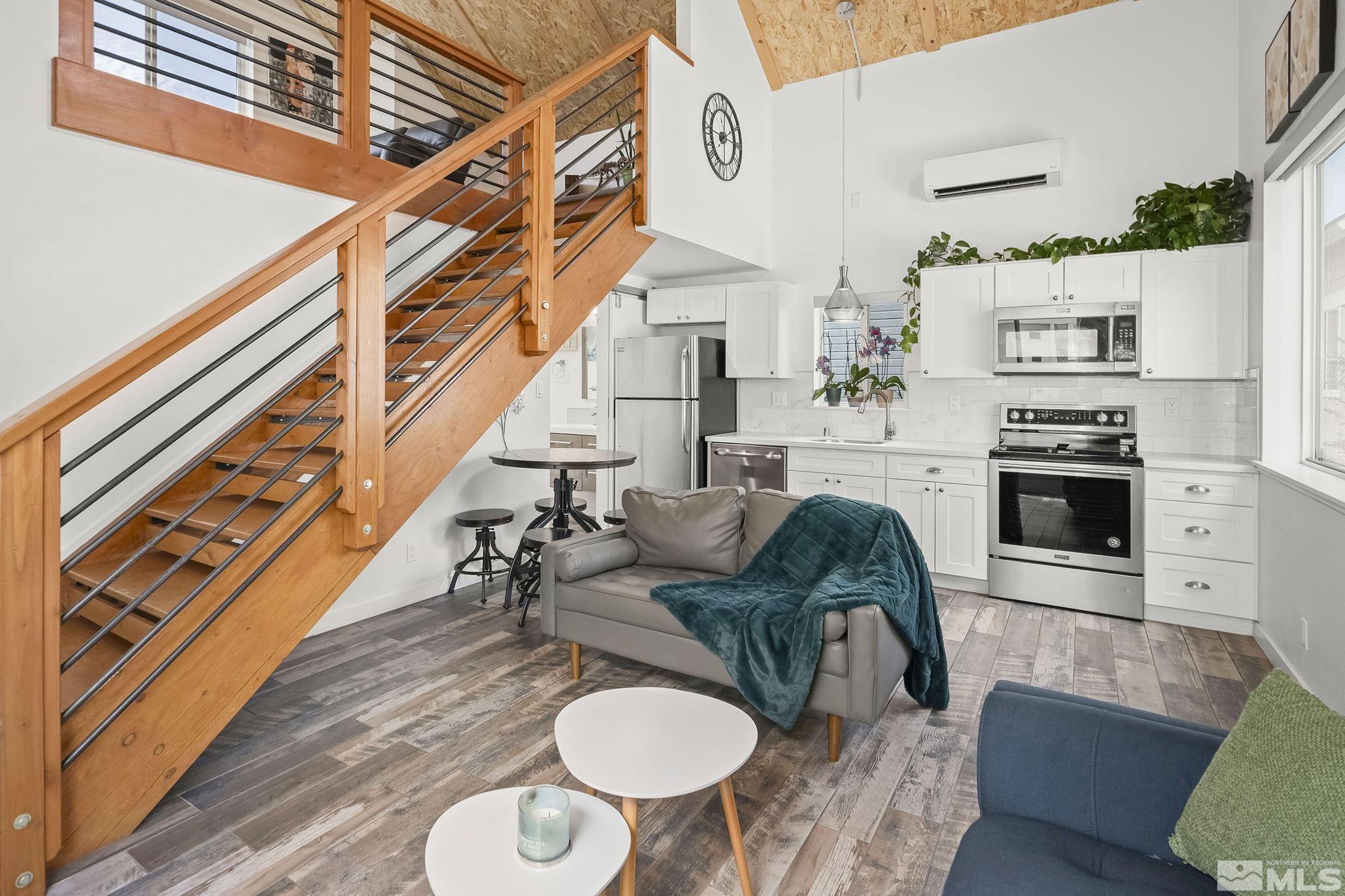 a living room with furniture a fireplace and a open kitchen view