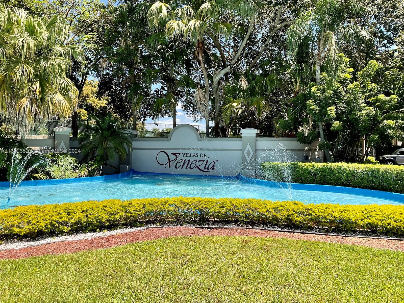 a view of swimming pool with a yard and large trees