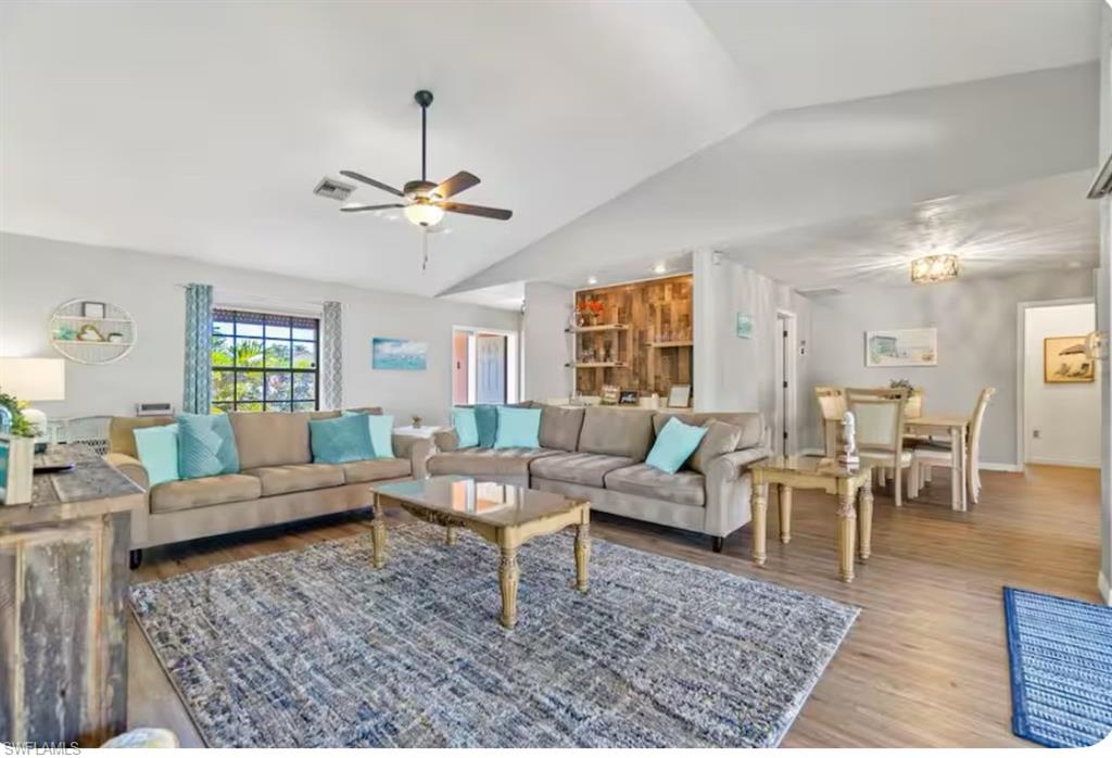 a living room with furniture a chandelier and a rug