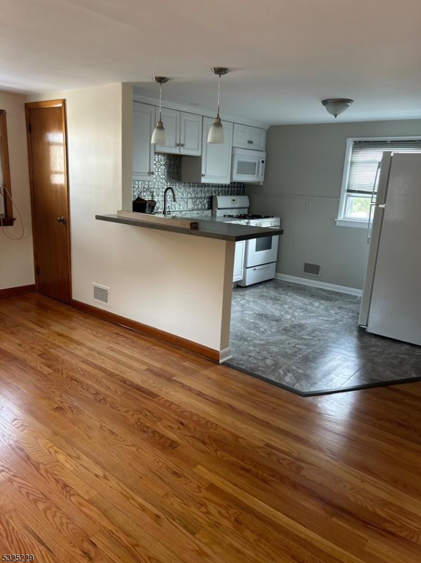 a kitchen with granite countertop a stove and a refrigerator