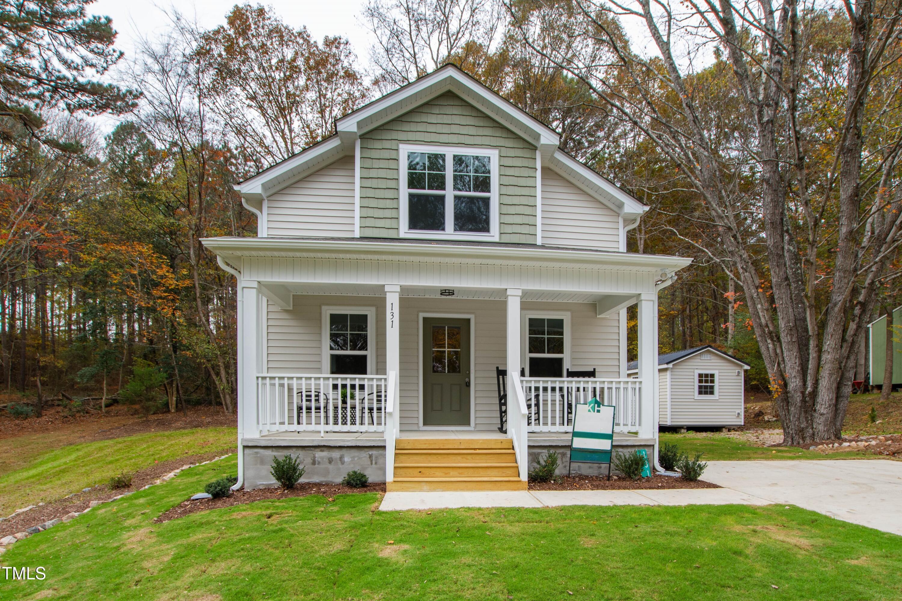 a view of a house with a yard and sitting area