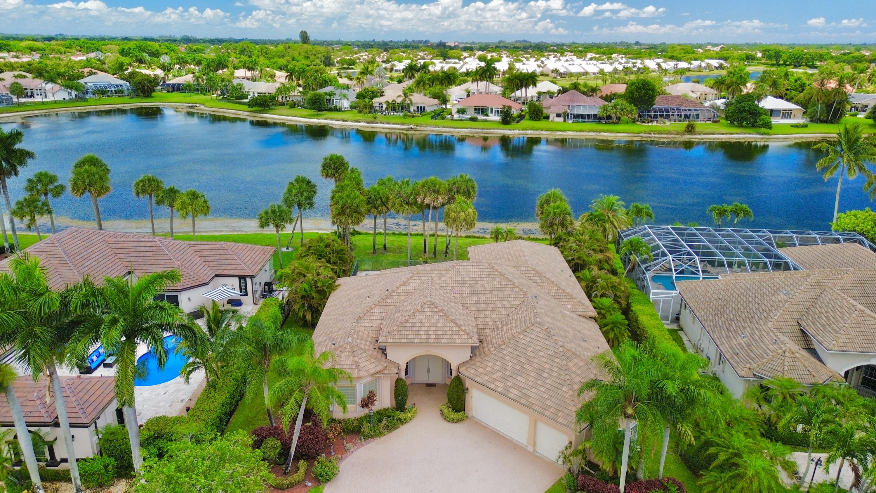 an aerial view of a house with a garden and lake view