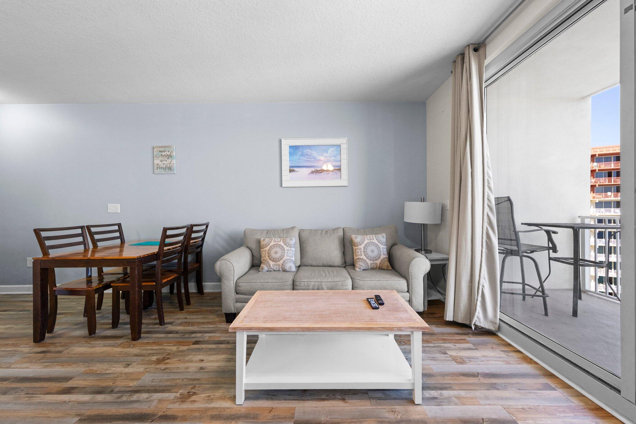 a living room with furniture a wooden floor and next to a window