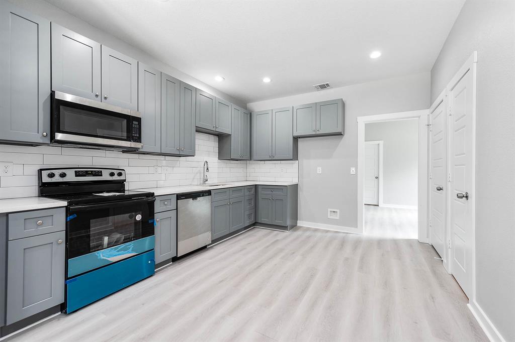 a kitchen with stainless steel appliances granite countertop a refrigerator and a stove top oven