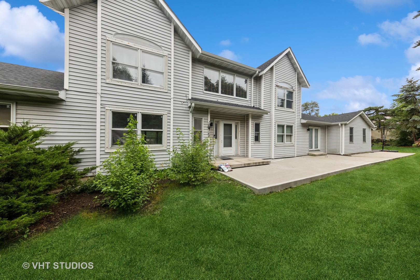 a front view of a house with a yard and trees