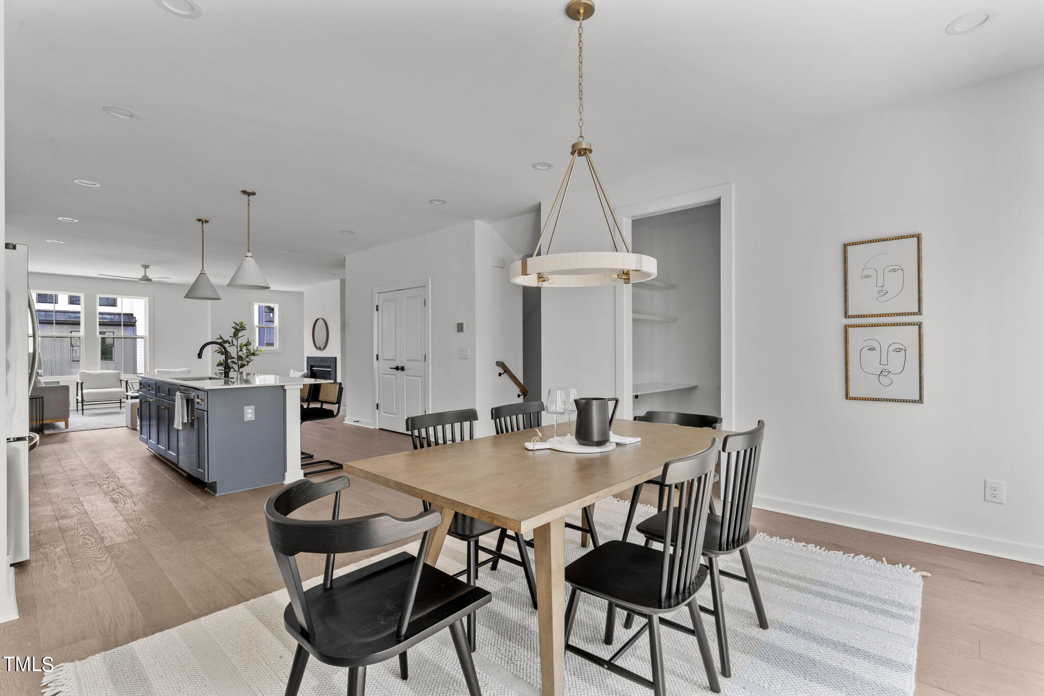 a view of a dining room and livingroom with furniture wooden floor a chandelier