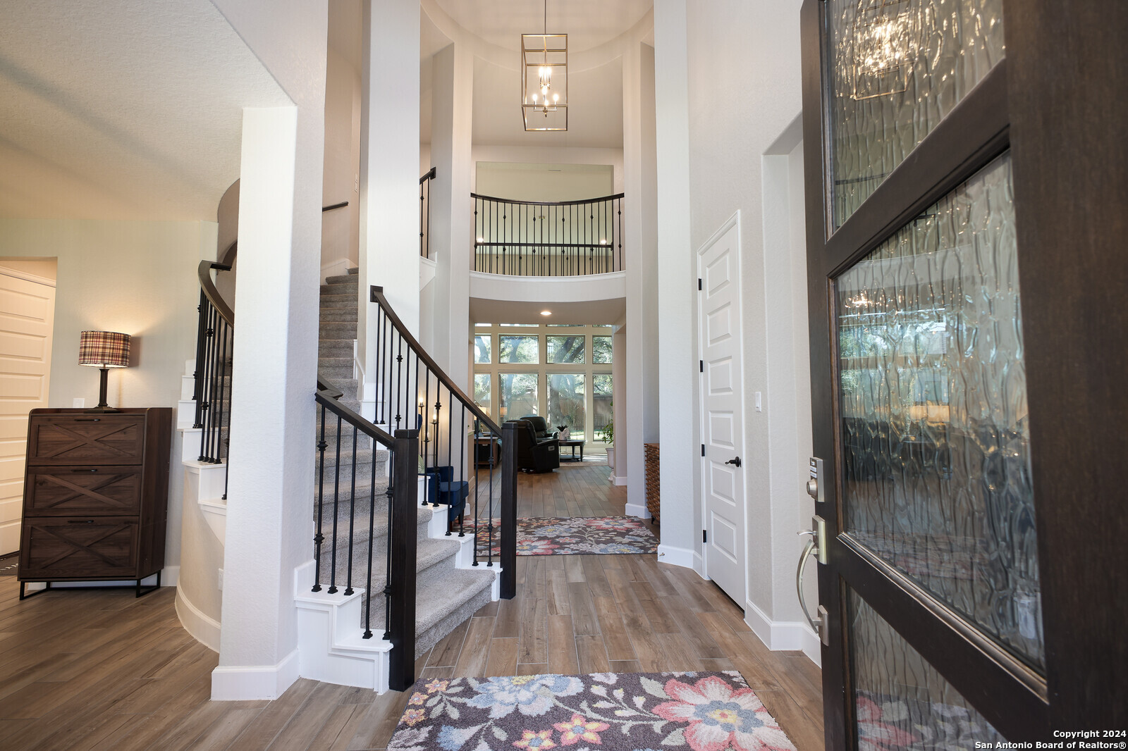 a view of a hallway with wooden floor and stairs