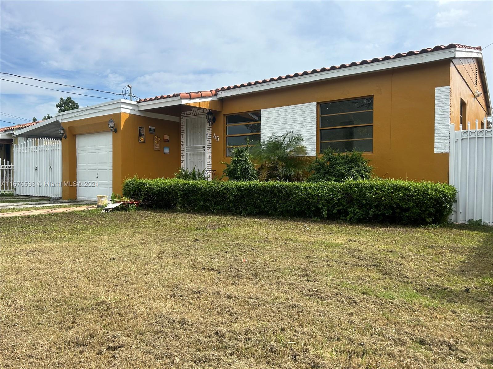 a front view of house with yard and trees in the background