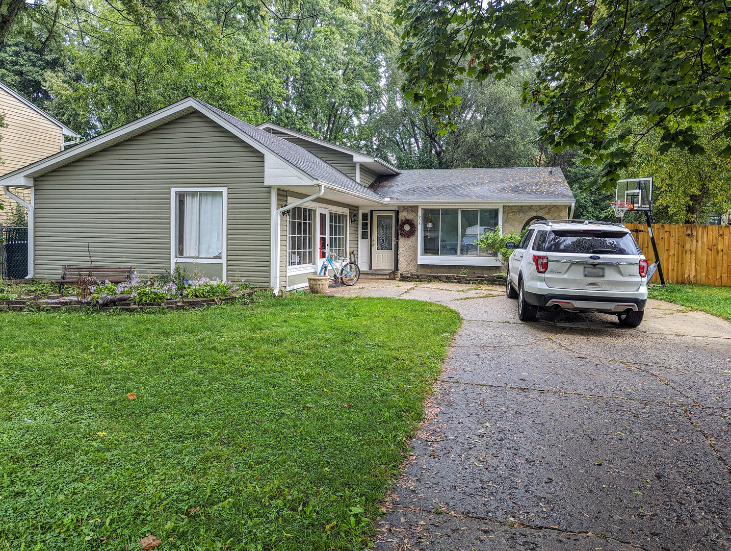 a front view of a house with a garden and trees