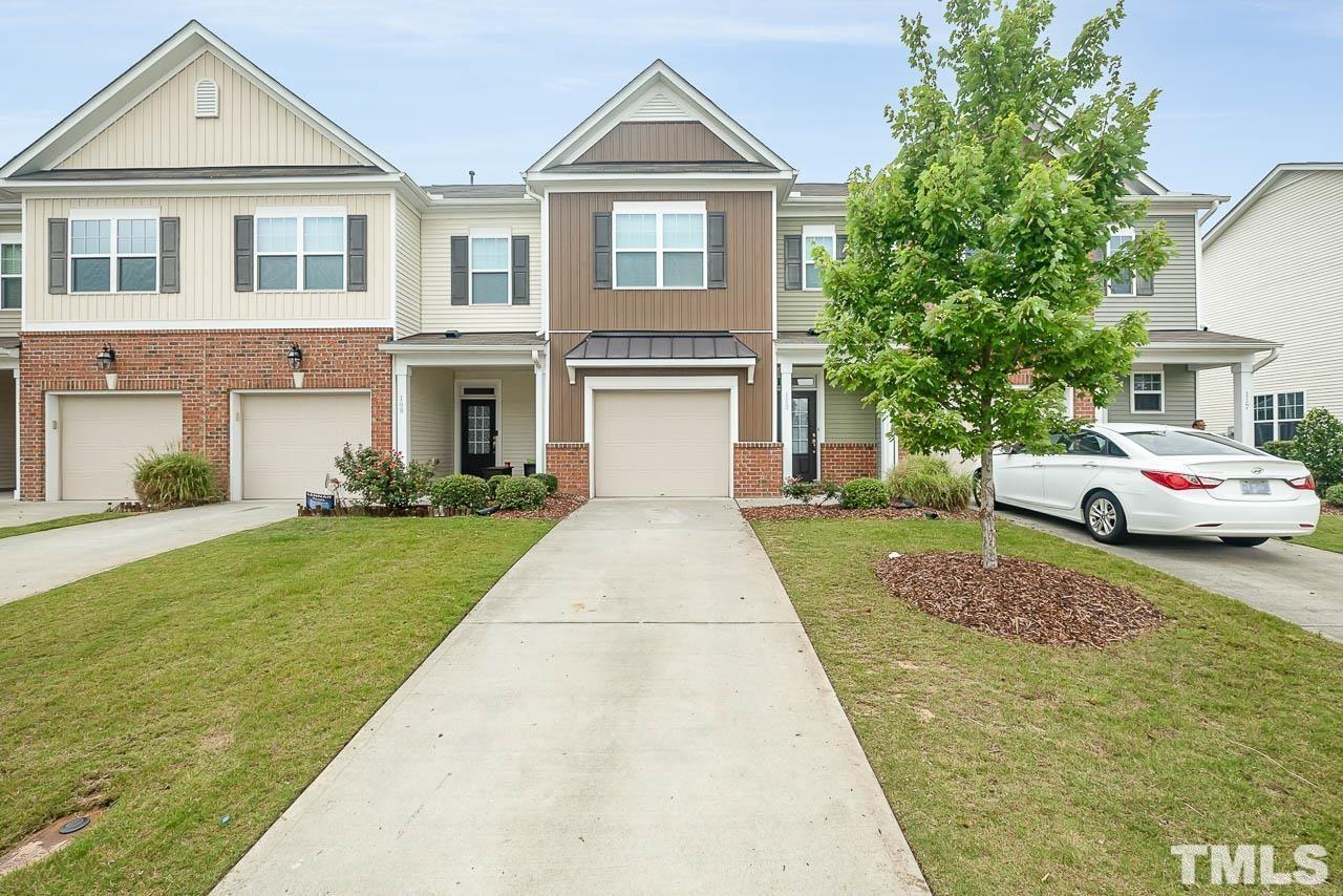 a front view of a house with a yard and garage