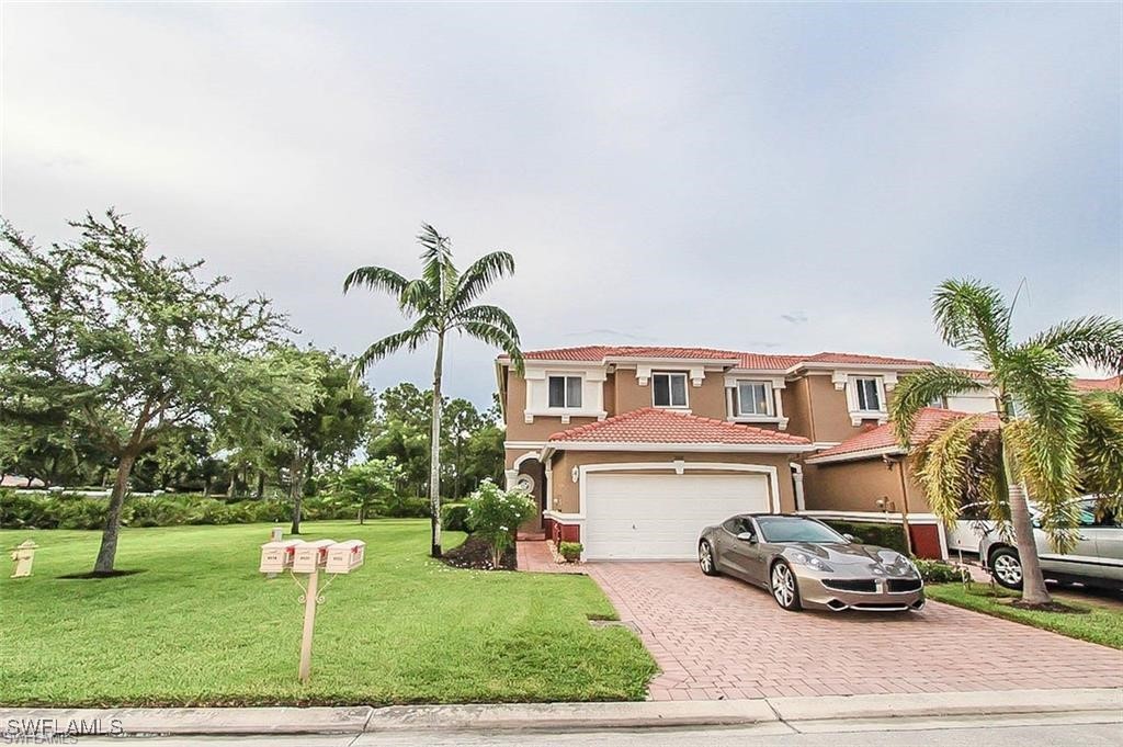 a front view of a house with a garden and parking