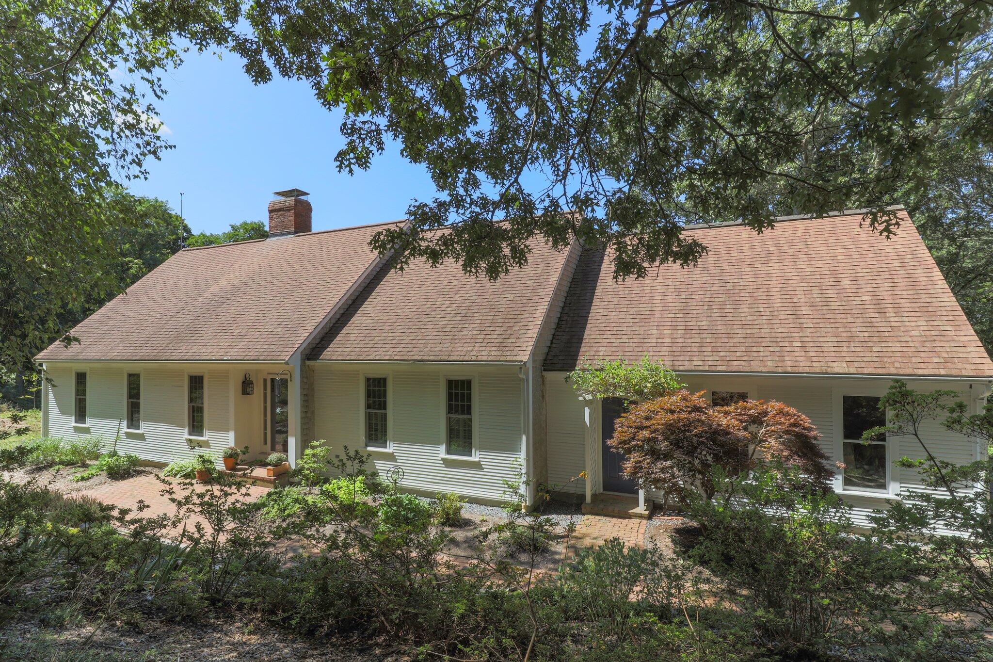 a view of a house with a garden and tree