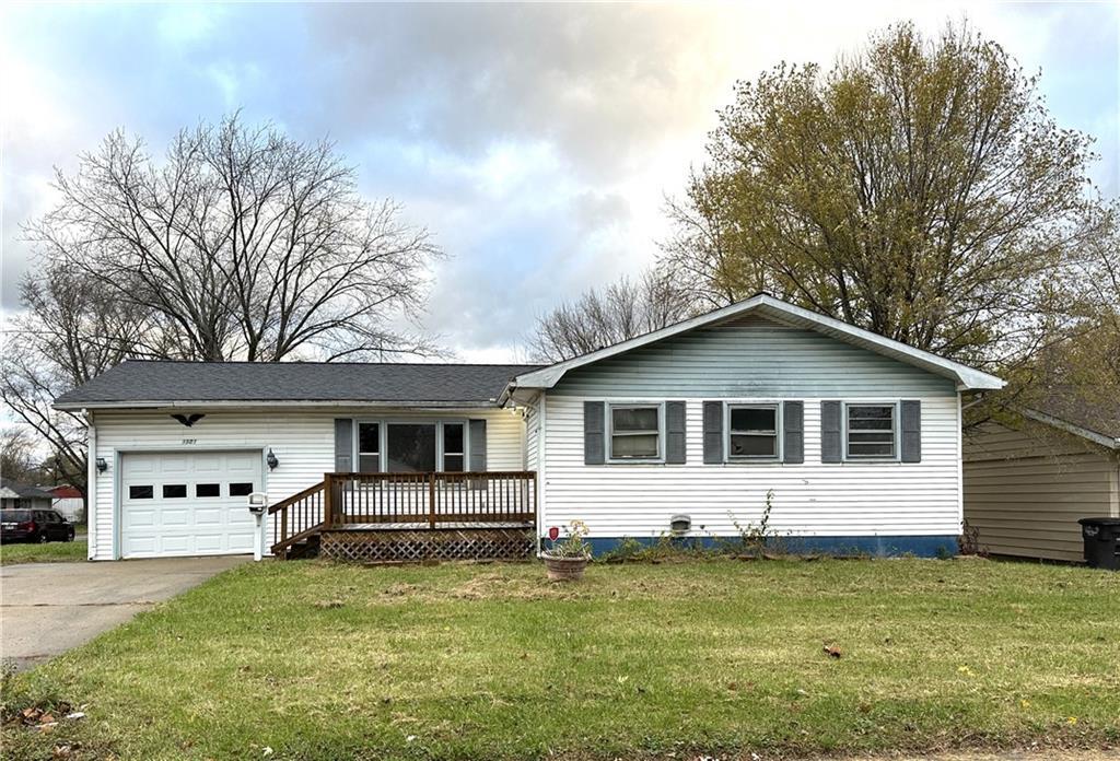 a front view of house with yard and trees in the background