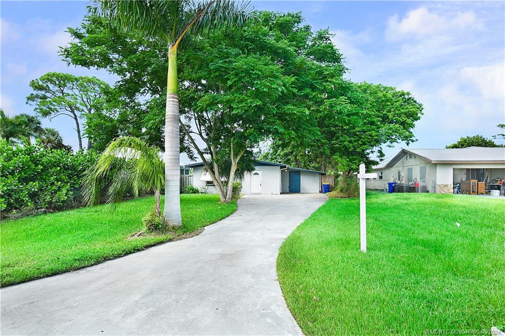 a view of a house with a yard and tree s