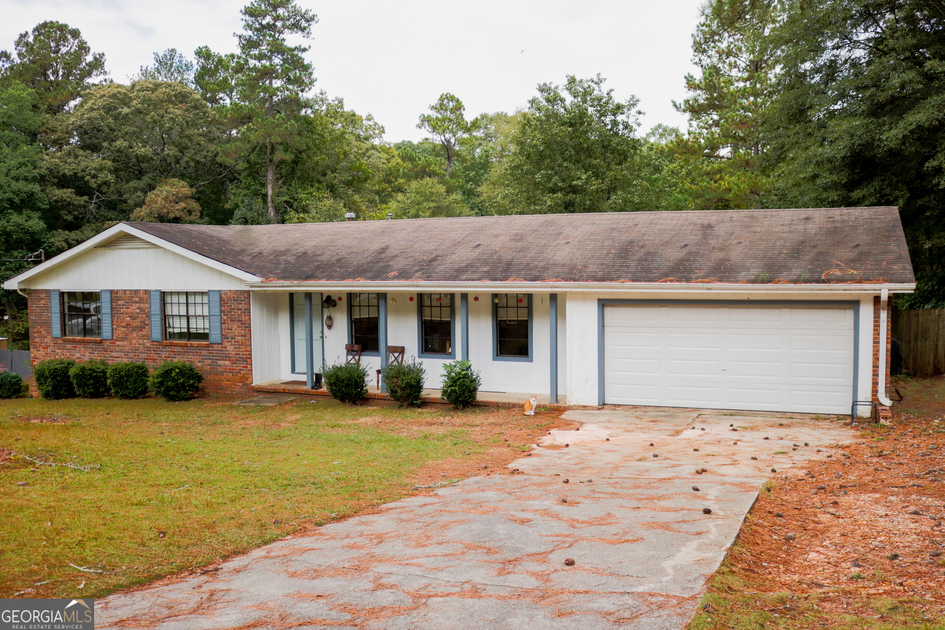 a front view of house with yard and trees in the background