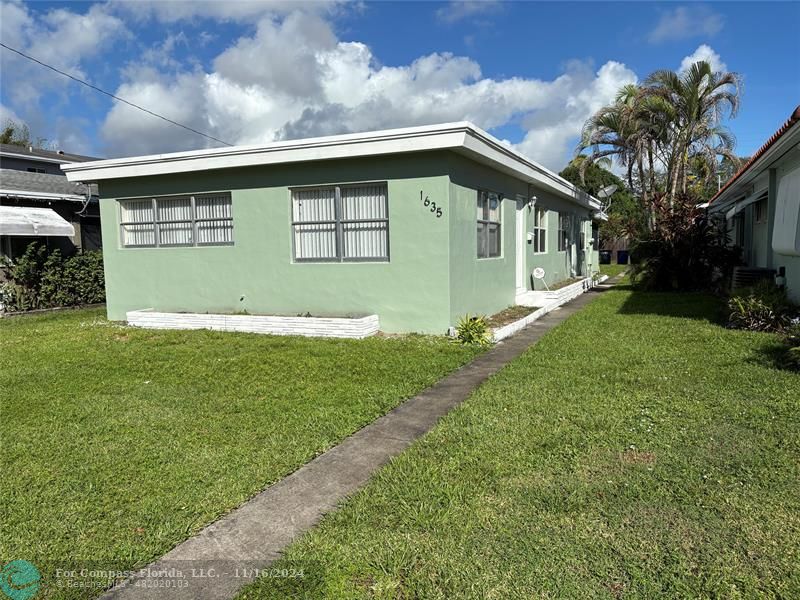 a house with green field in front of it