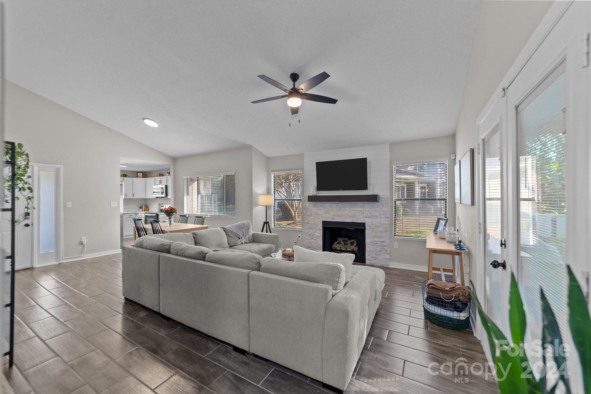 a living room with furniture a fireplace and a flat screen tv