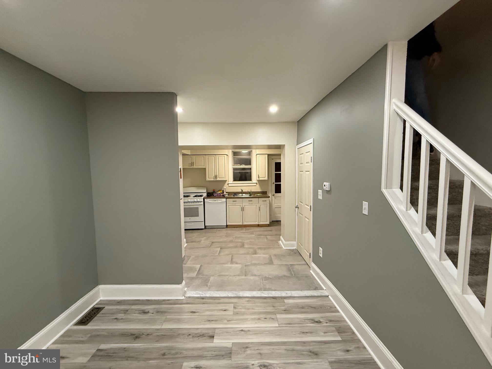 a view of a hallway with wooden floor and staircase