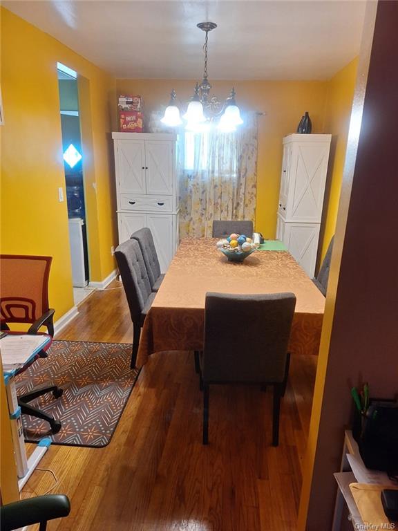 Dining room featuring wood-type flooring and an inviting chandelier