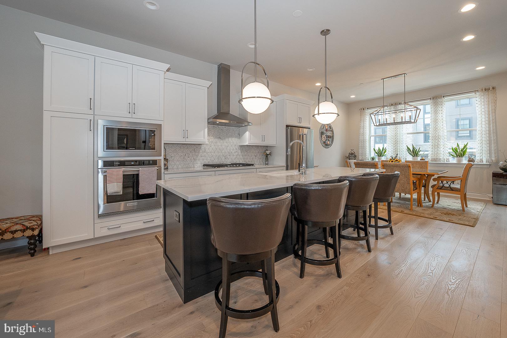 a kitchen with a dining table chairs stainless steel appliances and cabinets