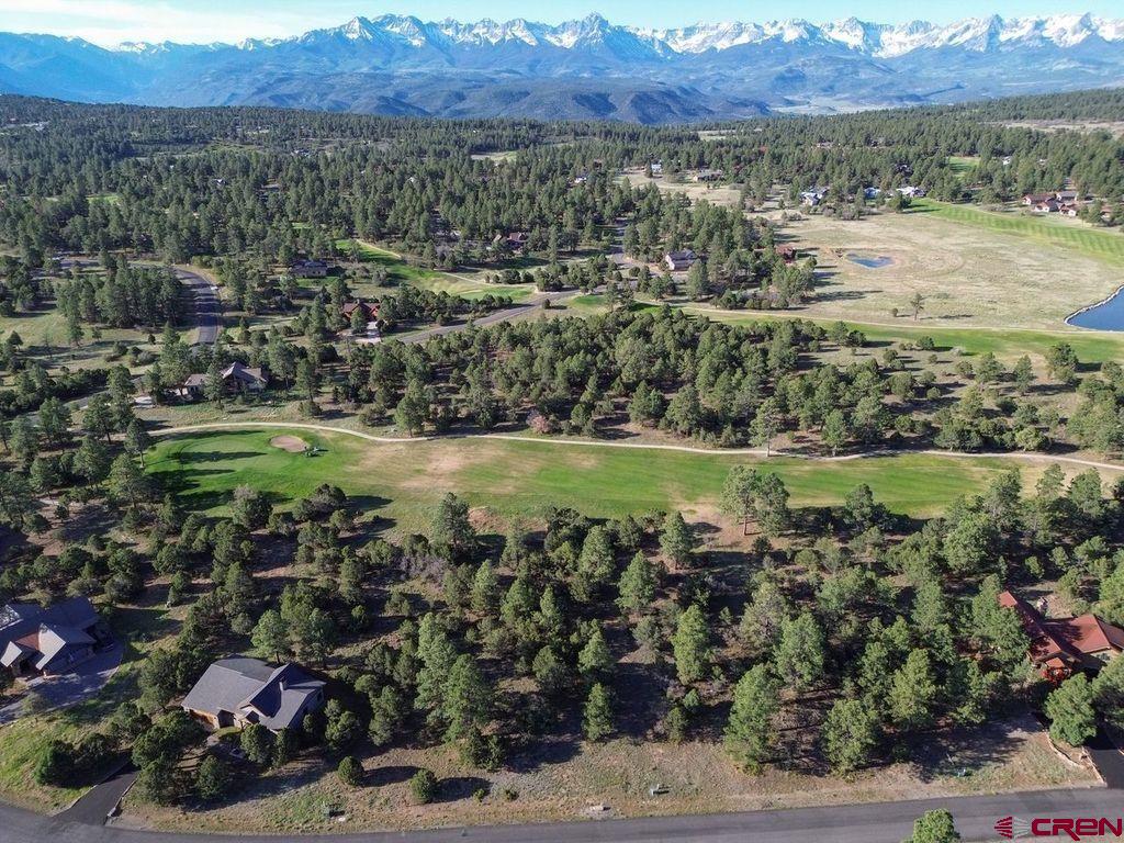 an aerial view of a houses with a yard and lake view