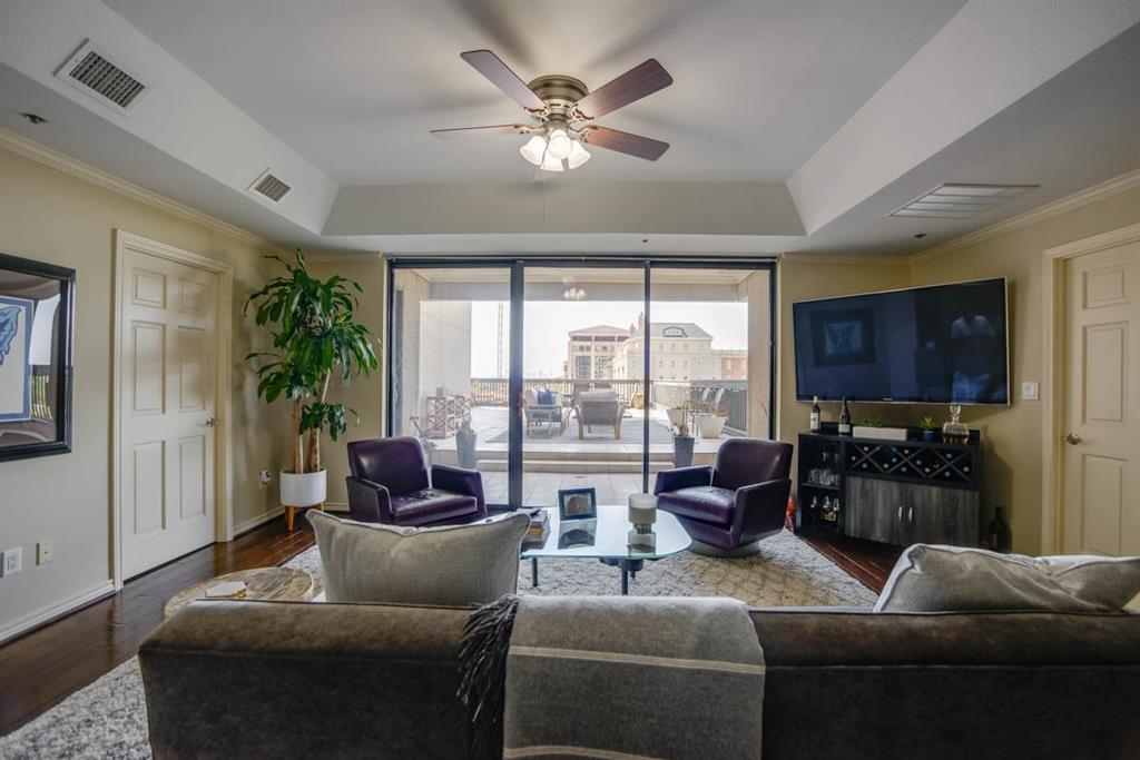 a living room with furniture ceiling fan and a large window