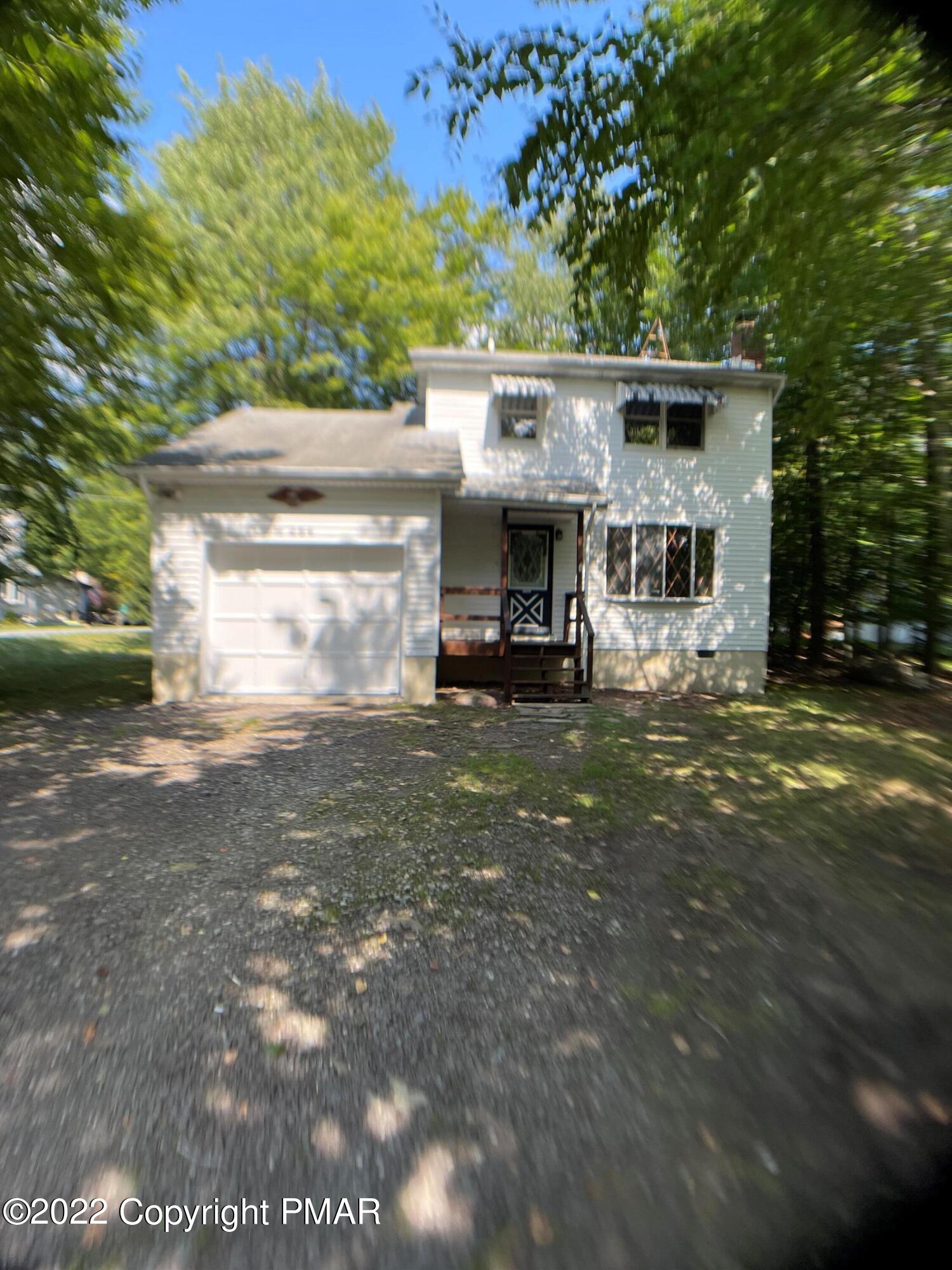 a view of house with outdoor space and parking